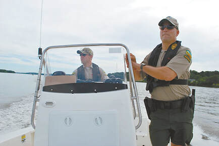 Two DNR officers patrol the Mississippi River in a DNR boat