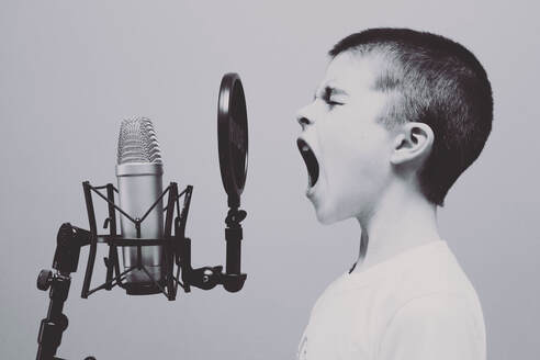 Little boy singing into microphone