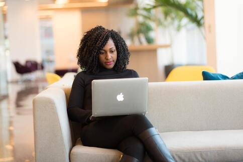 African American woman using Apple laptop